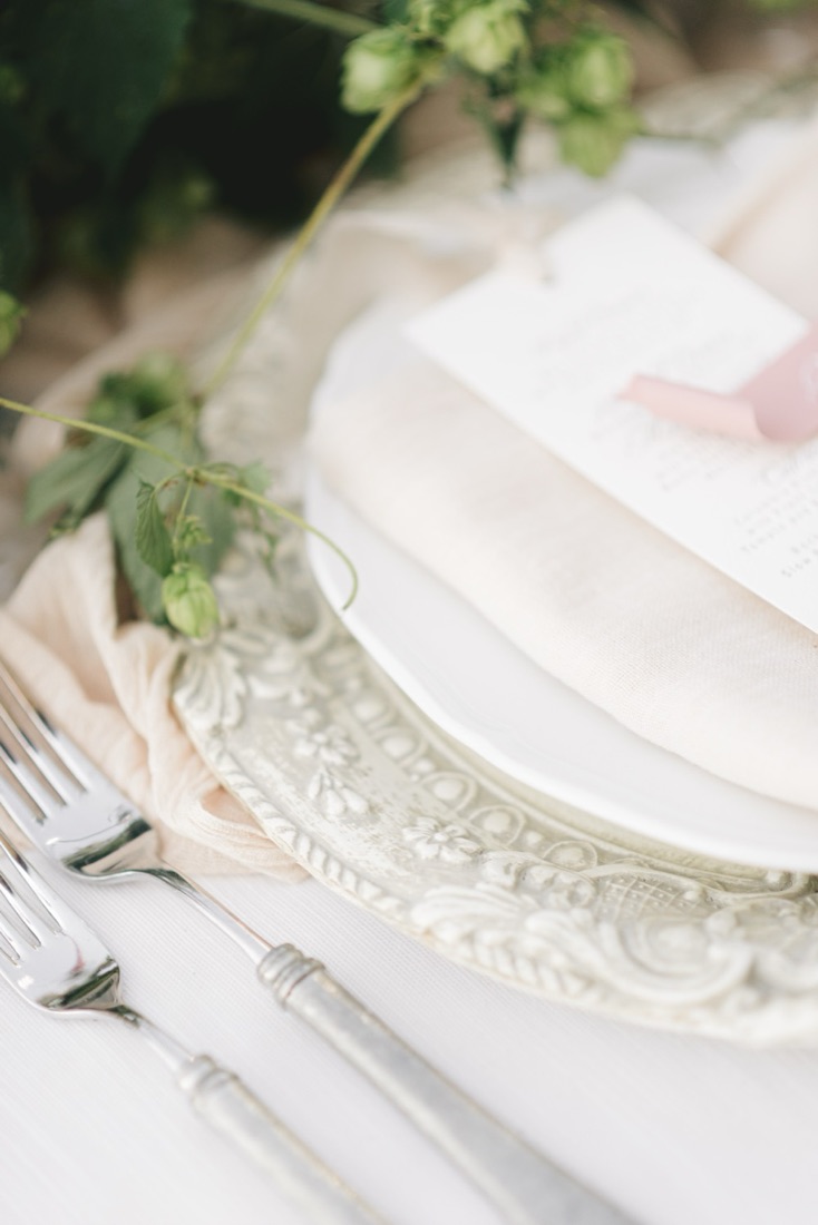 Vintage place setting with an engraved charger plate, place card and hop vine sprig