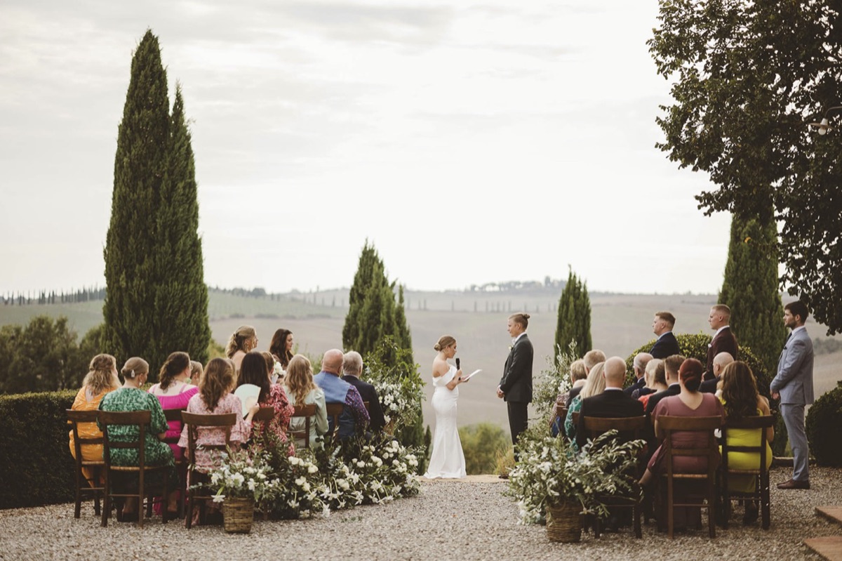 Outdoor countryside wedding ceremony among cypress trees overlooking the Tuscan hills