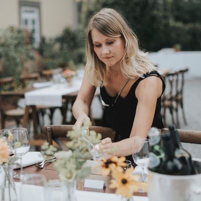 Anne styling a reception tablescape with fresh flowers at a Tuscany wedding
