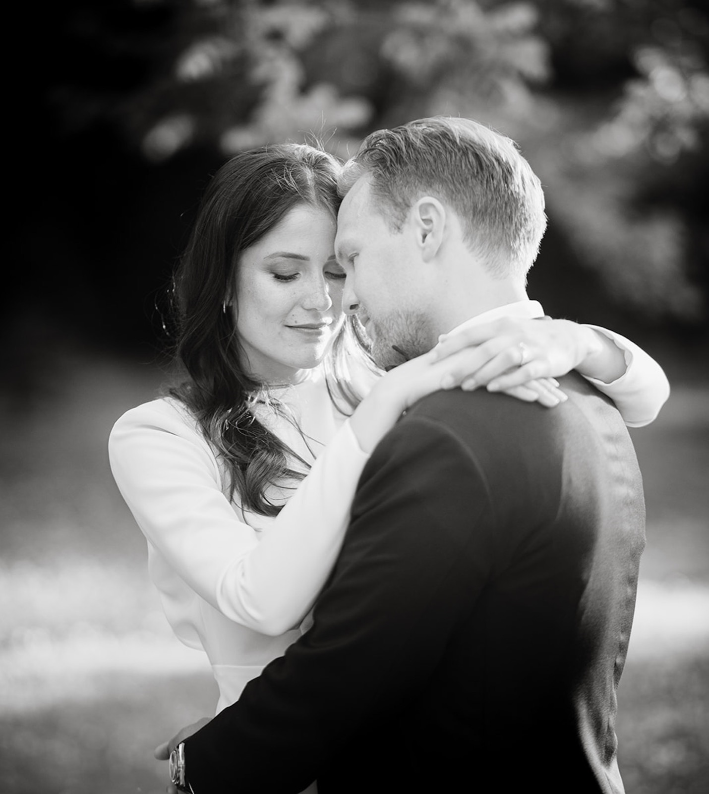Emma and Teemu embracing forehead to forehead in a black and white portrait