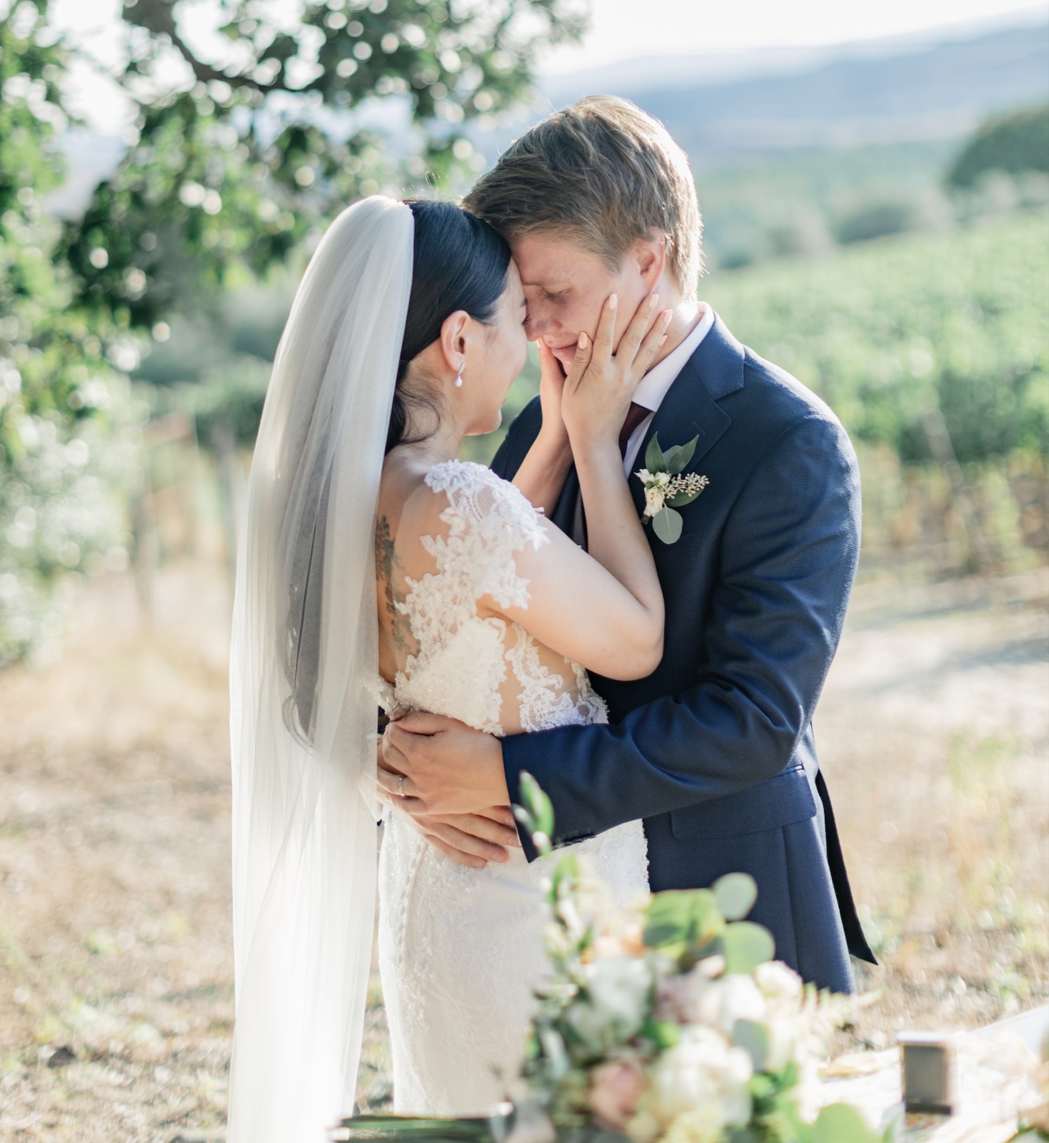 Lisa and Jarkko embracing forehead to forehead beside a Tuscan vineyard